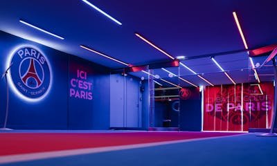 Spacious PSG entrance hallway in Paris with striking neon lighting and club branding.