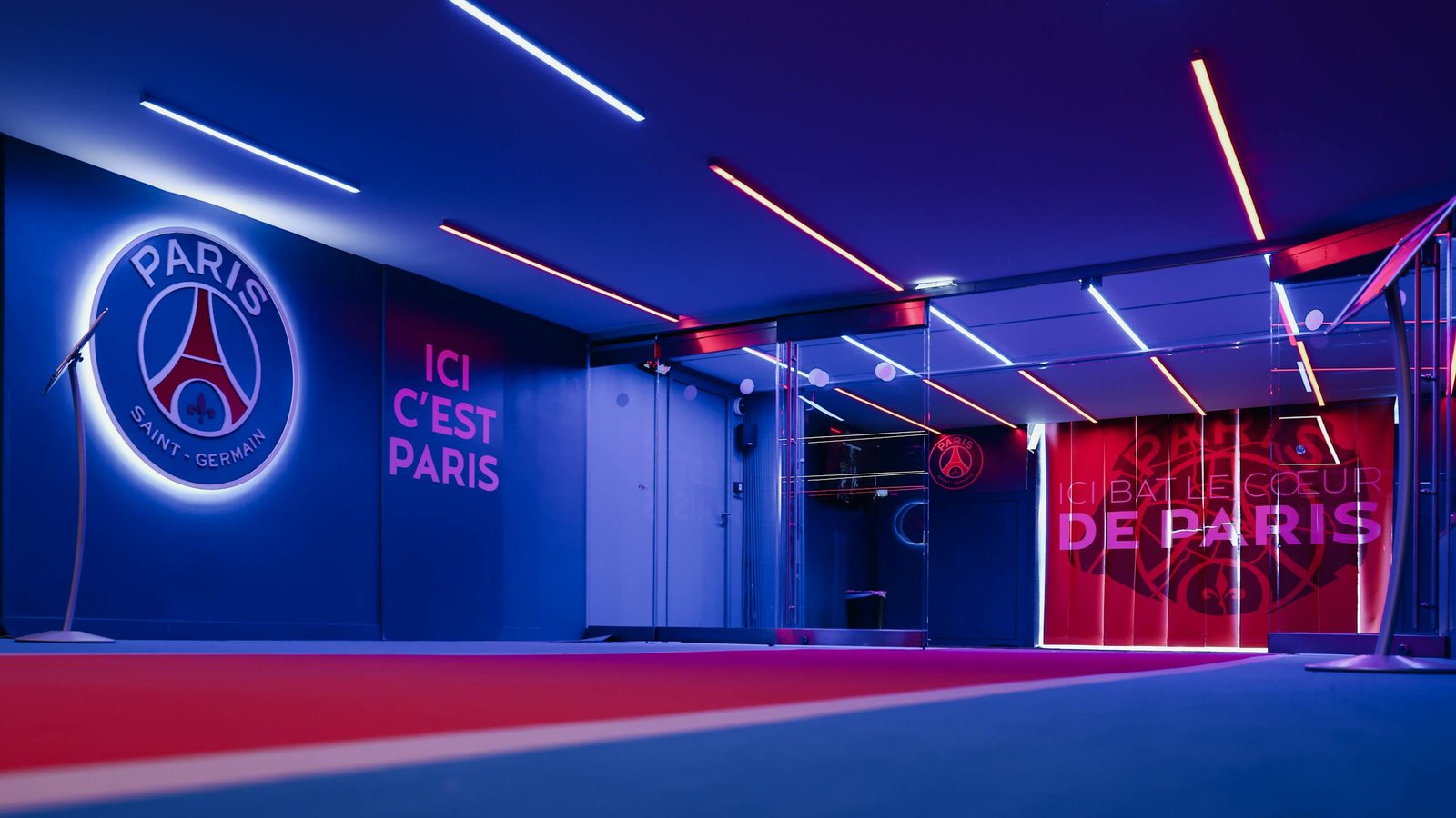 Spacious PSG entrance hallway in Paris with striking neon lighting and club branding.